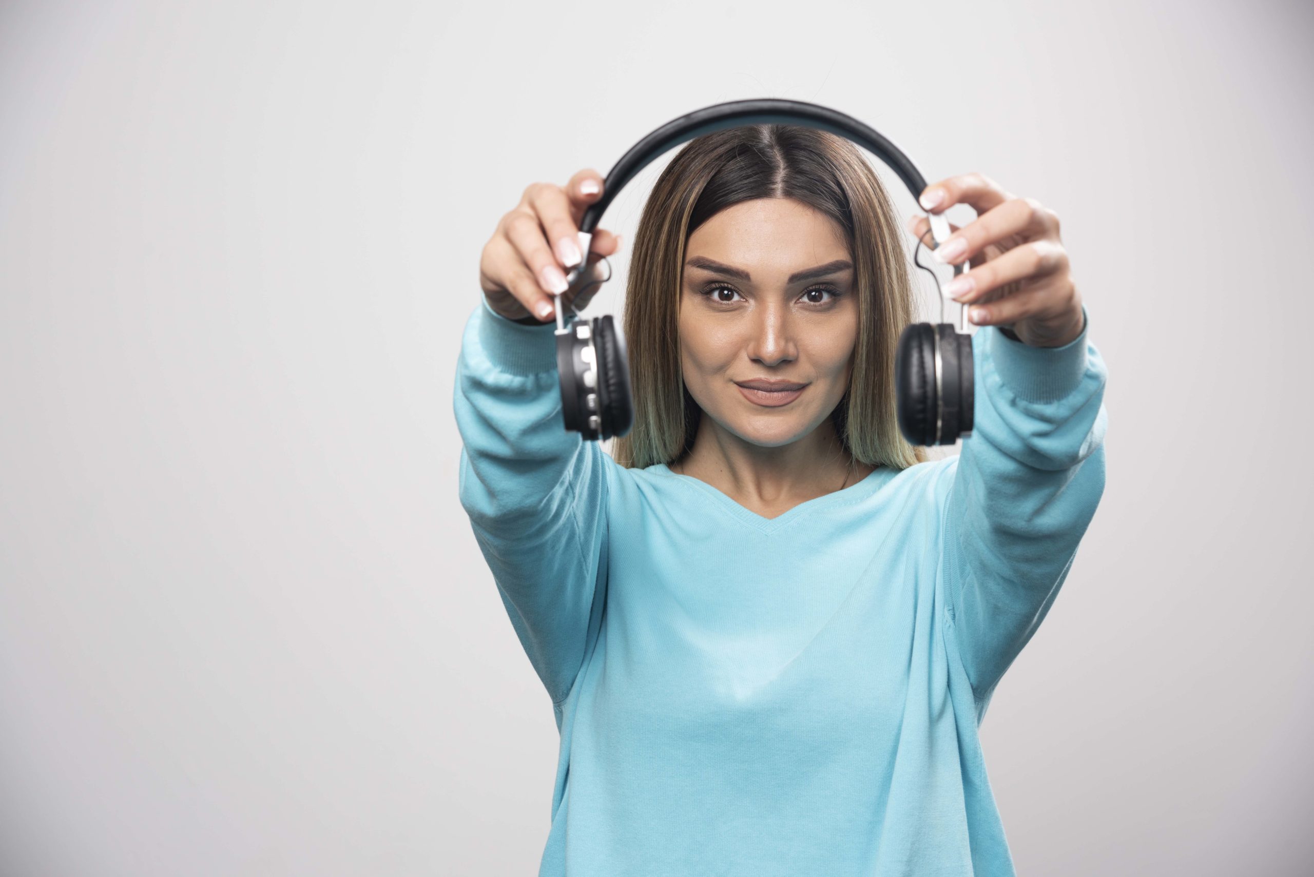 Holding headphones at arms length (From: Freepik)