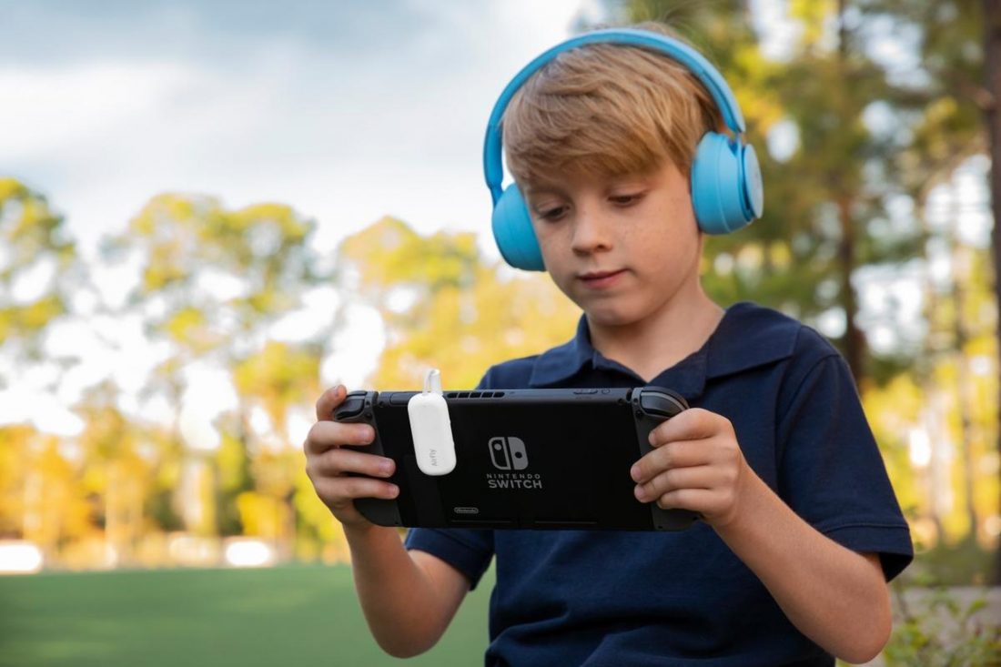 A boy using headphones while playing with a device (From newatlas.com)