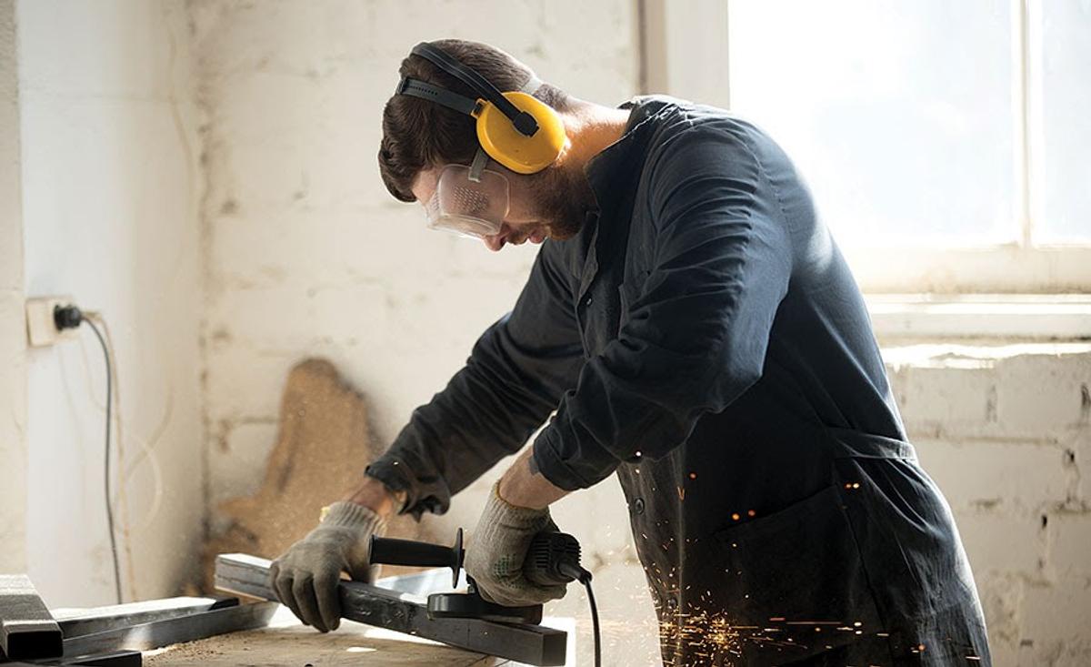 A guy wearing earmuffs while working (From: ISHN)