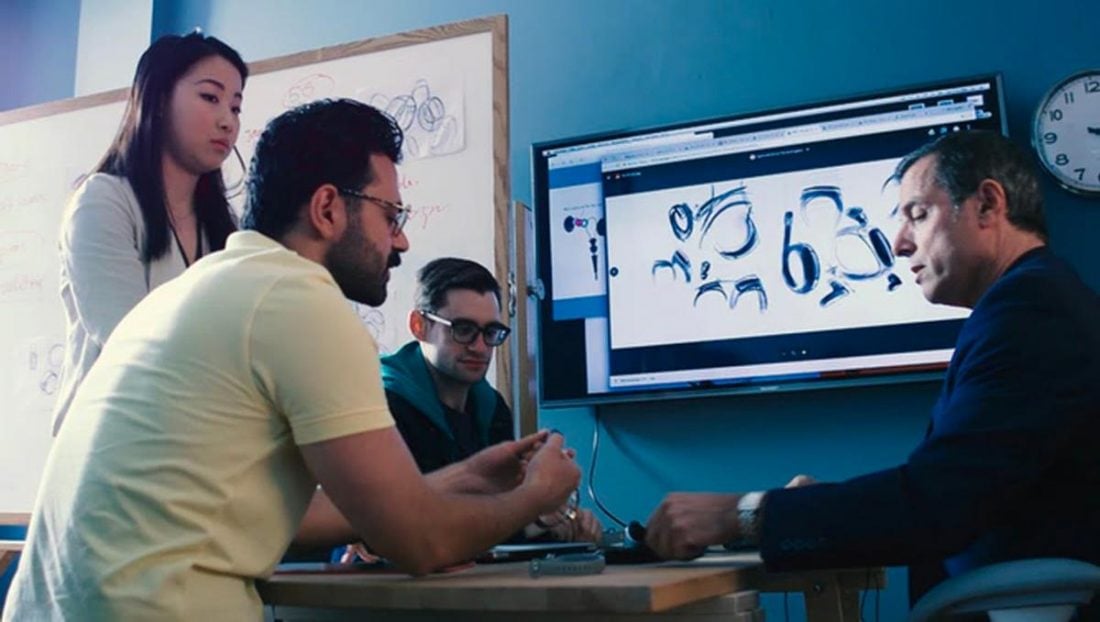 Promotional picture of the team discussing the Wearbuds. Notice that the one person wearing a watch isn't wearing the Wearbuds. (From indiegogo.com)