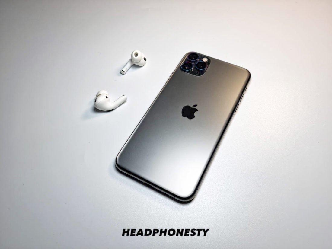 A pair of AirPods beside an iPhone