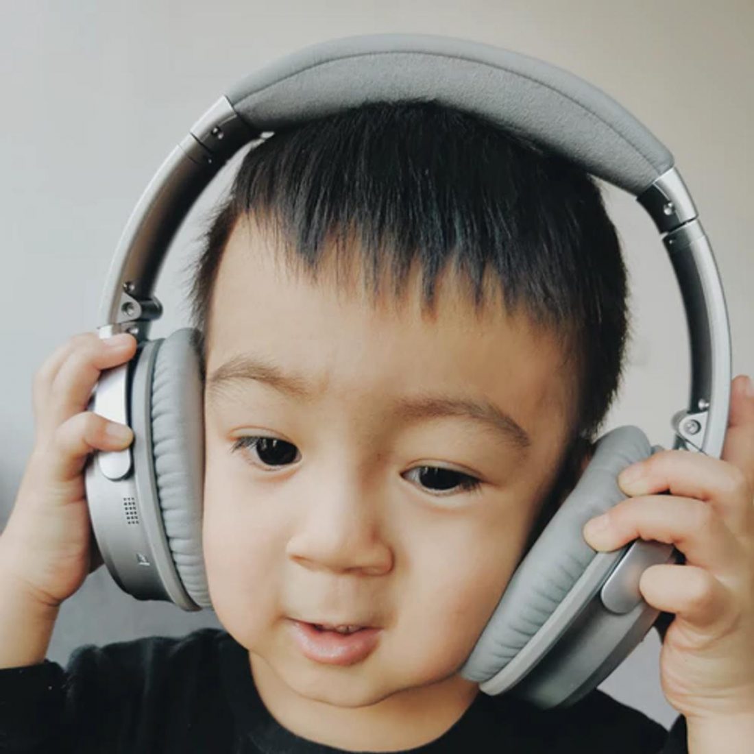 Boy wearing headphones that do not fit him well. (From: Unsplash)