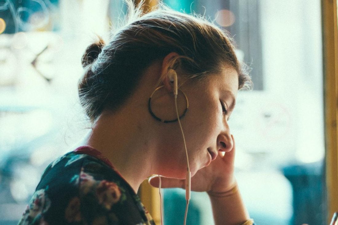 Earbuds hurting woman's inner ears (From: Unsplash)