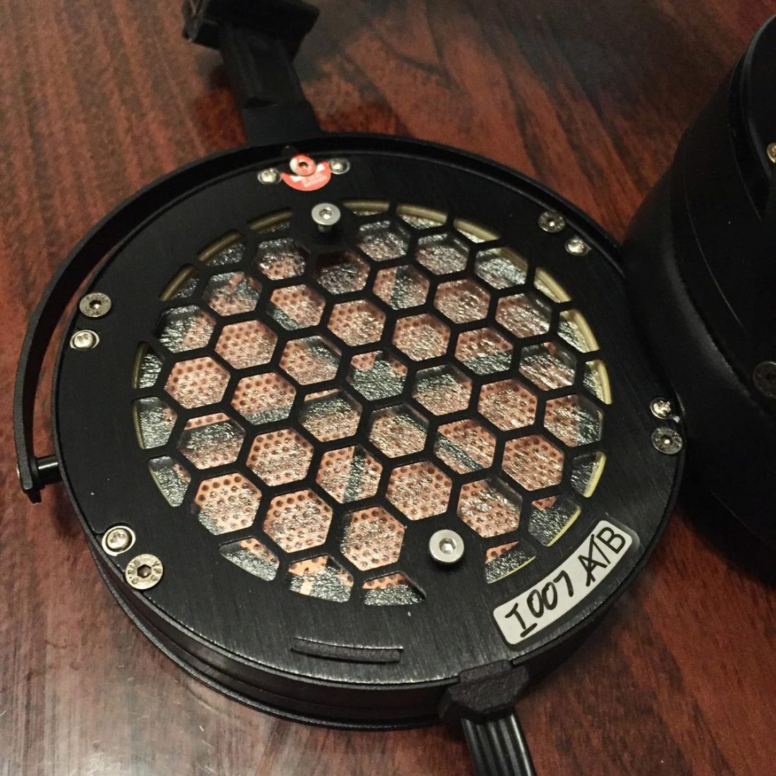 The earpads are held on by two screws; taking the earpads off is pretty quick and painless. Beyond that is the dust cover, and beyond the dust cover is the stator - the hexagonal pattern is to prevent damage.
