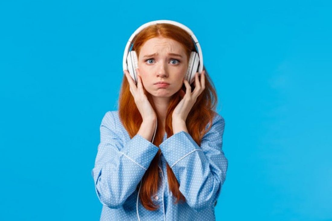 Girl disappointed in headphones while listening (From: FreePik)