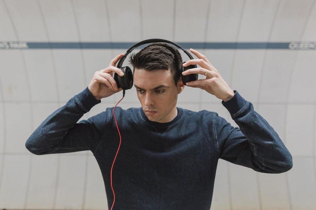Photo of a man looking unsure about using a set of cushioned headphones (From: pixabay.com)
