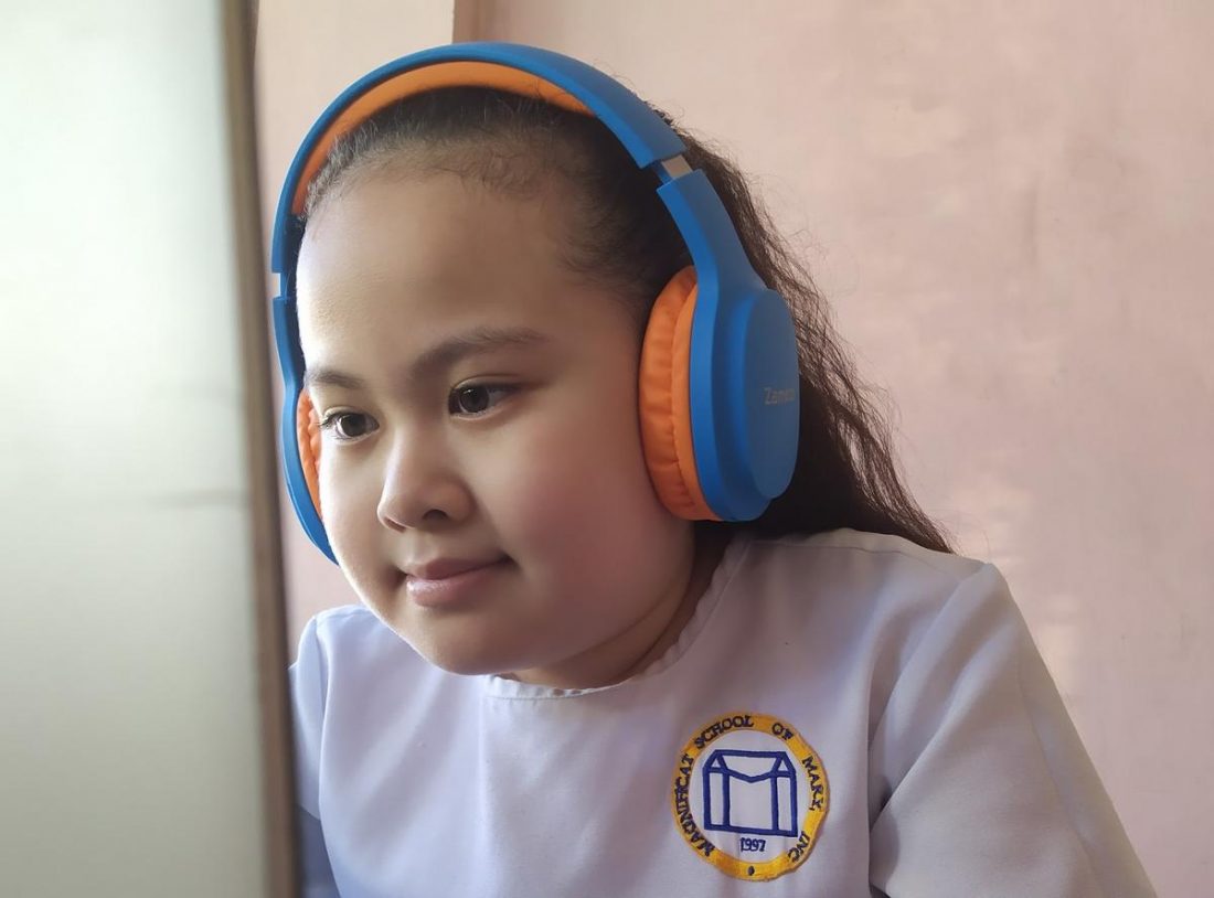 My little sister using the headphones during her online class