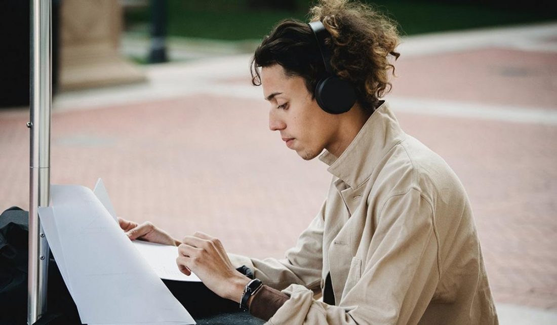 Student studying while wearing wireless headphones (From: Pexels)