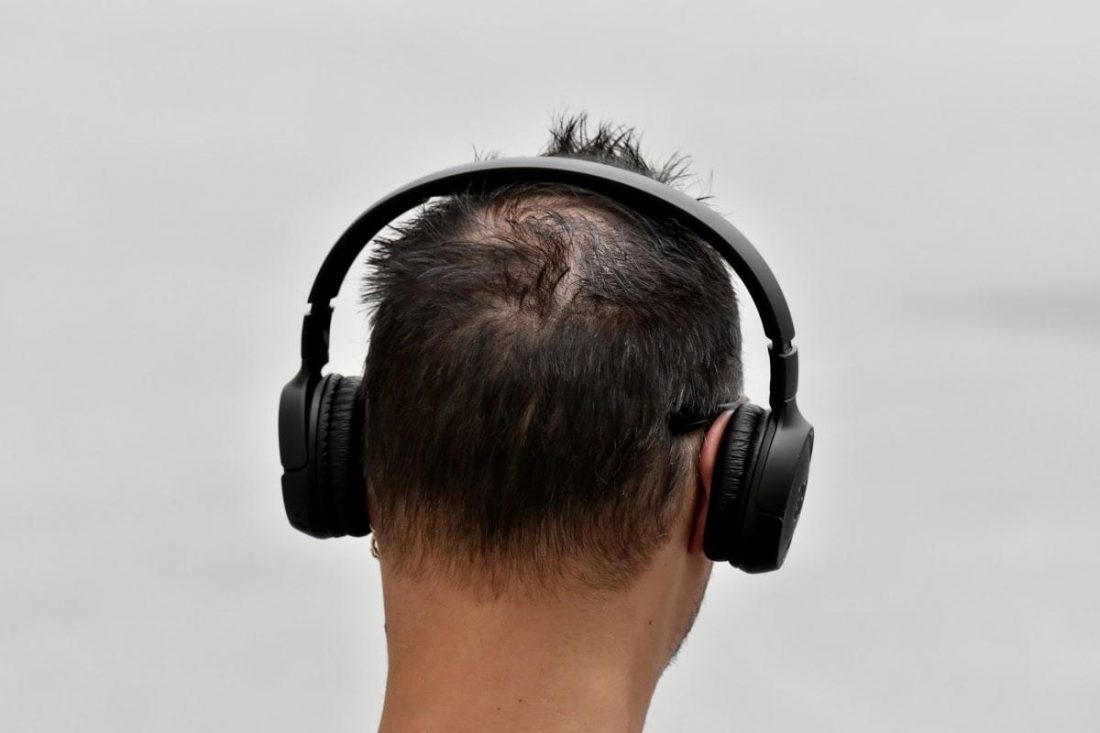 Back view of man wearing on-ear headphones (From: Pixnio)