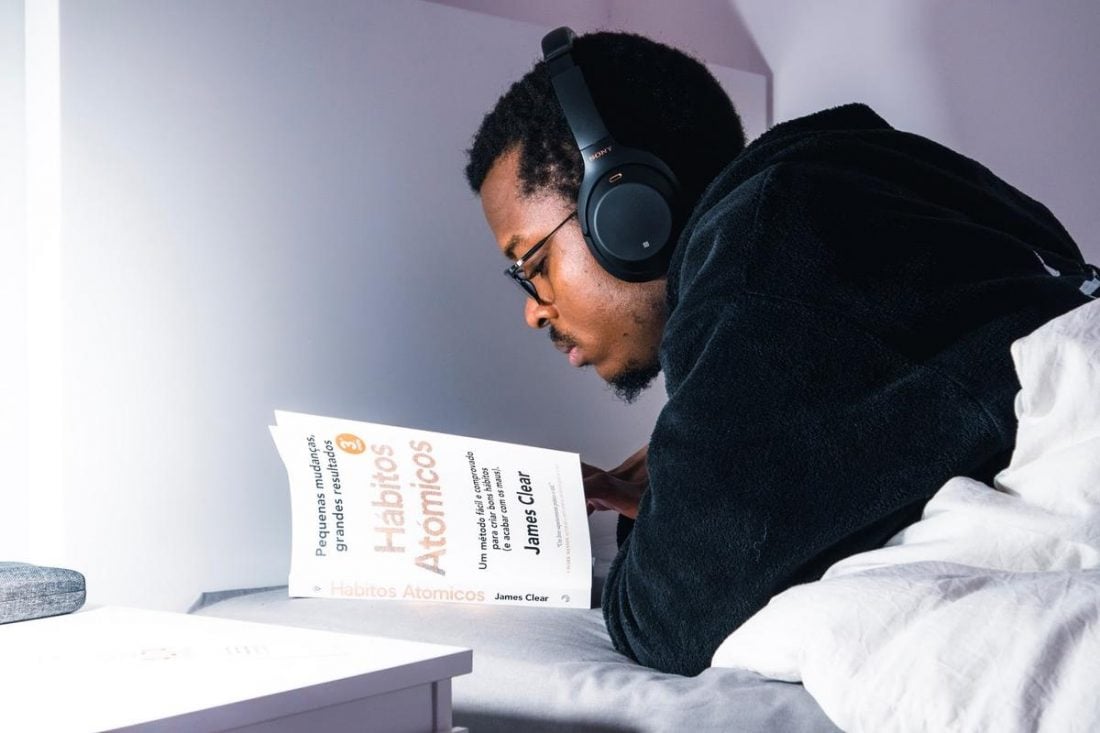 Man reading with headphones (From:Unplash).