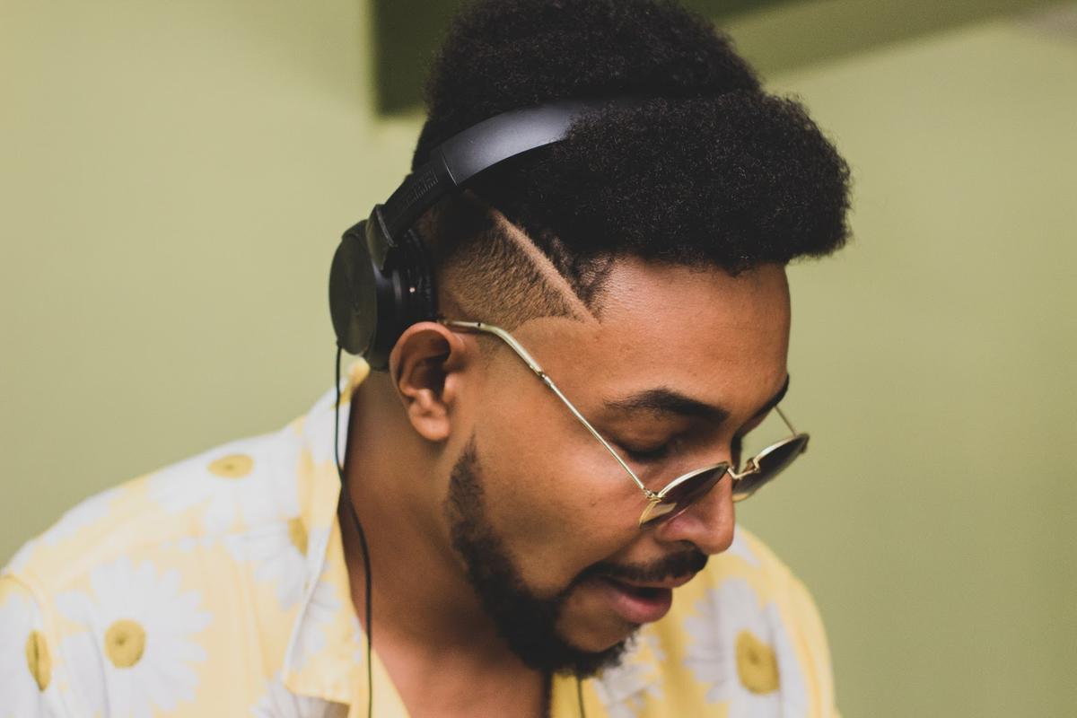 A man wearing headphones has his hair flattened by the headband. (From: Unsplash)