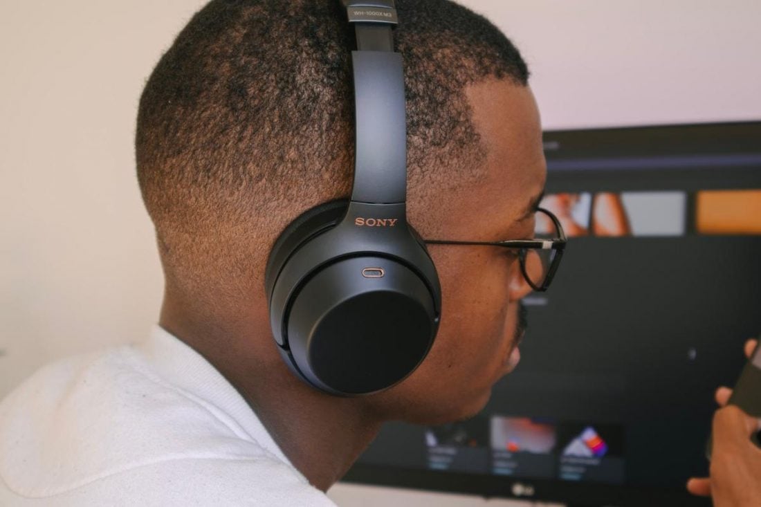 A man with buzzed cut wears headphones. (From: Unsplash)