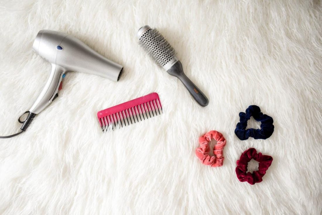Different hair styling tools and products laid out on a flat surface. (From: Pexels)