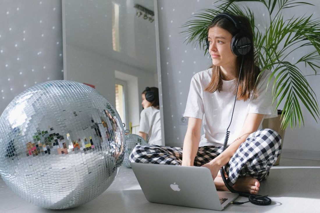 Girl using headphones on Mac (From: Pexels)