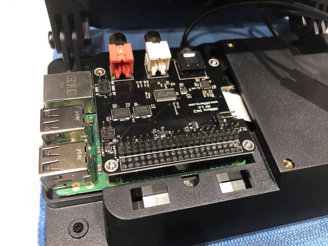 The DAC HAT (black) is installed on top of the Pi (green).