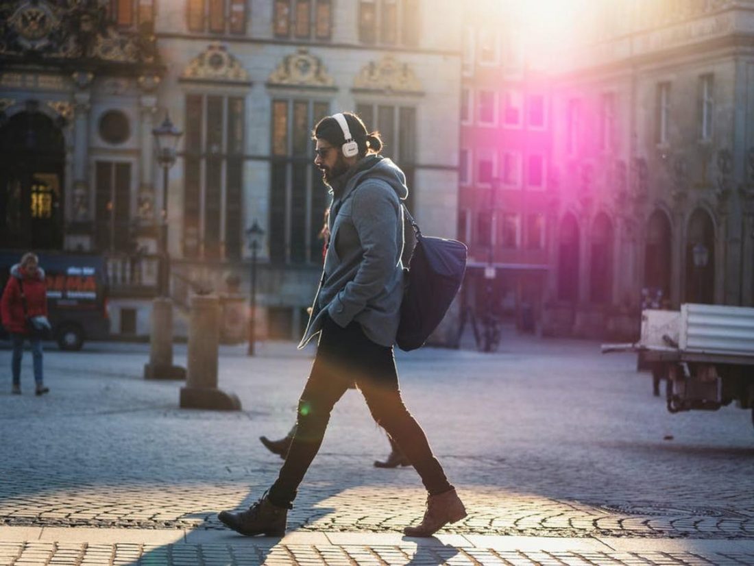 Man walking outside while listening to music (From: Pexels)