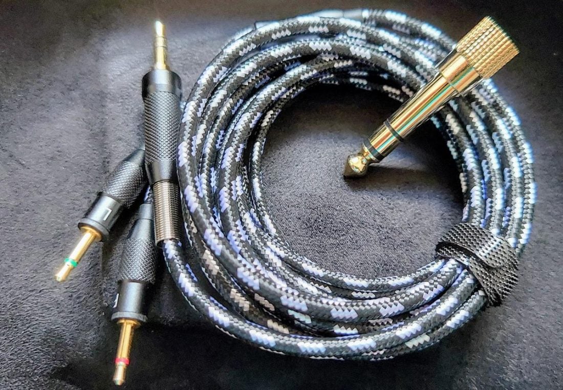 The distinct black and silver 2m cloth-jacketed OFC unbalanced cable, with gold plated electrical contacts, machined metal connectors, and strain reliefs.