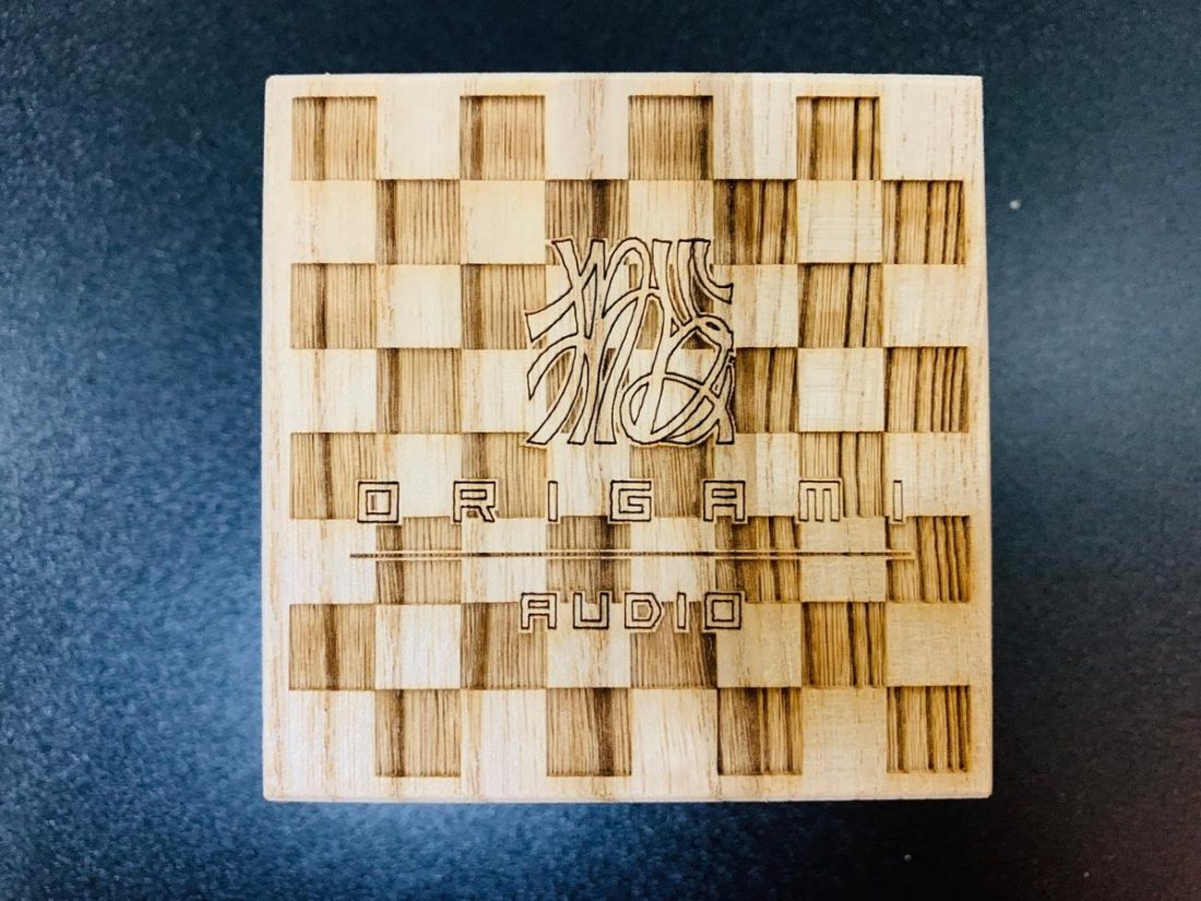 Origami Audio logo and checkerboard pattern engraved on the wooden box.