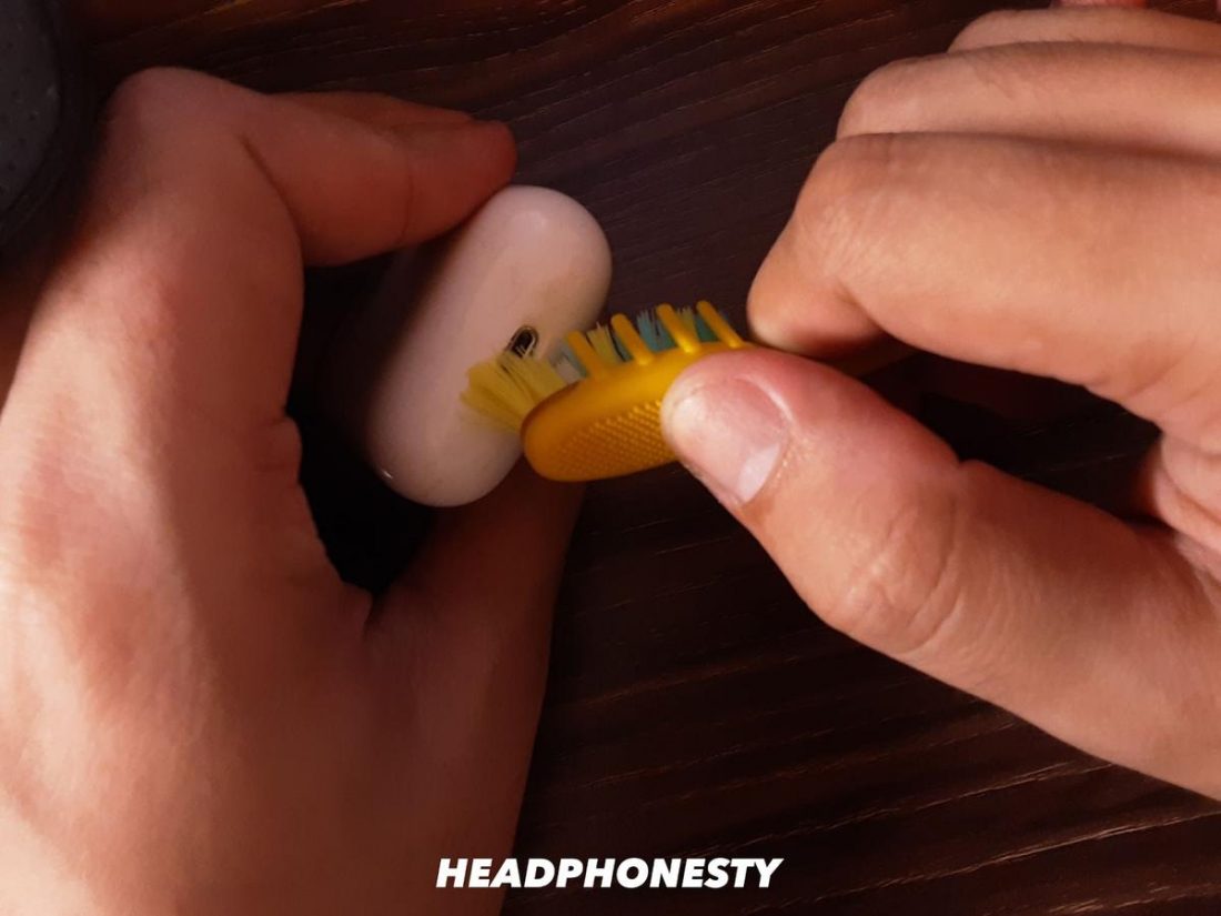 Cleaning the AirPods charging port with a toothbrush