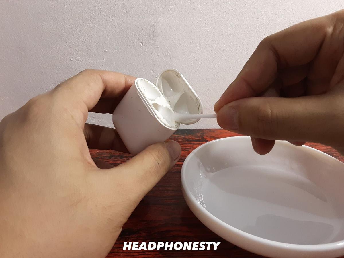 Cleaning AirPods Case with a cotton swab