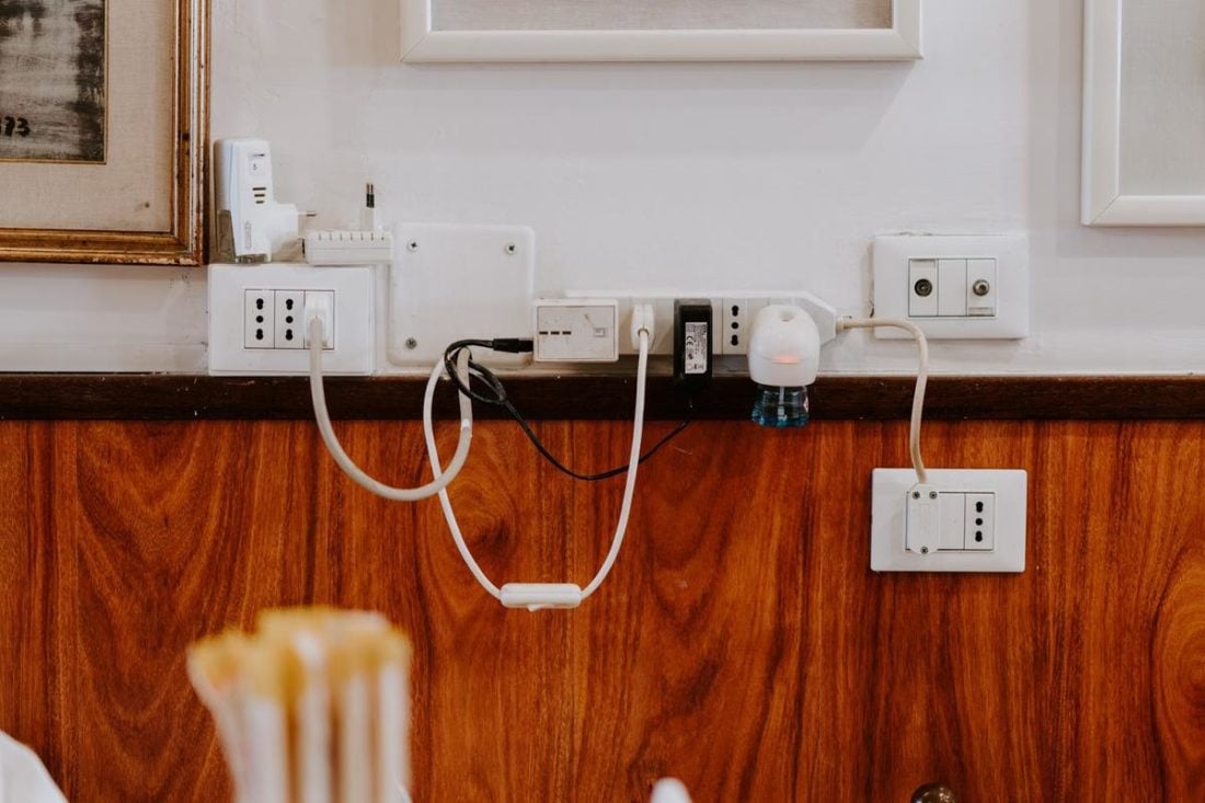 Multiple plugs connected to wall sockets (From: Unsplash)