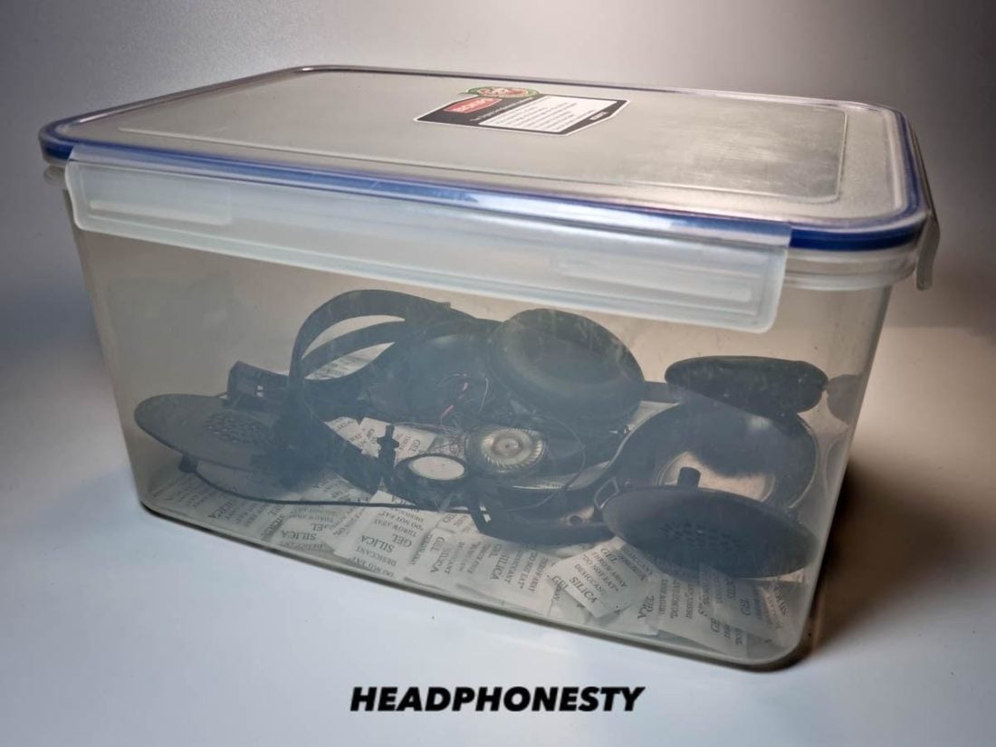 Headphones enclosed in container with dessicant