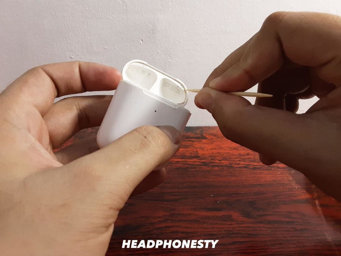 Using a toothpick to reach inside your AirPods