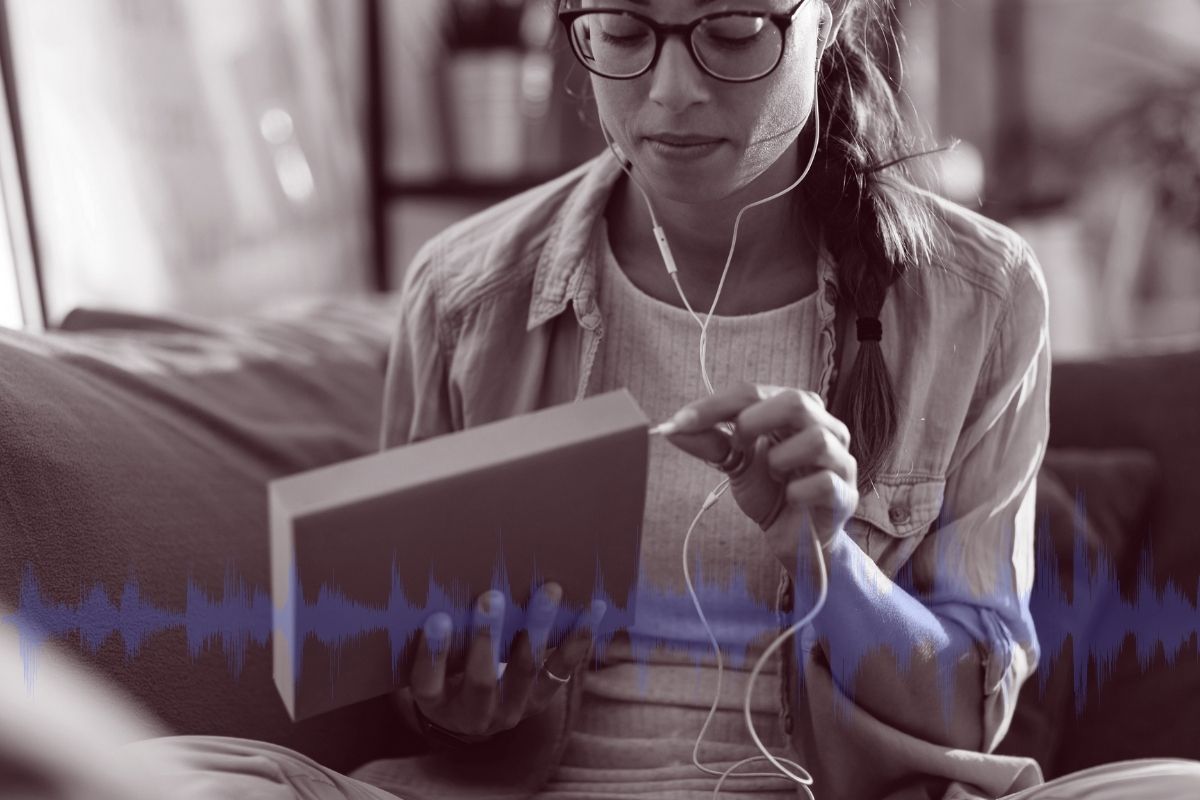 Woman plugging headphones on book