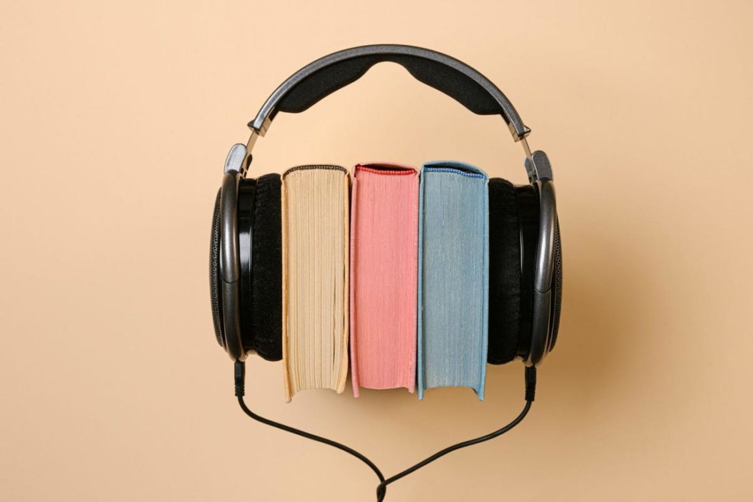 Headphones clamping three books (From: Pexels)
