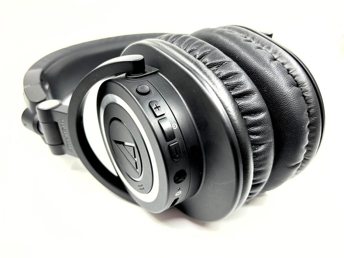 Control buttons, charging port, and analogue input are located on the left ear cup.