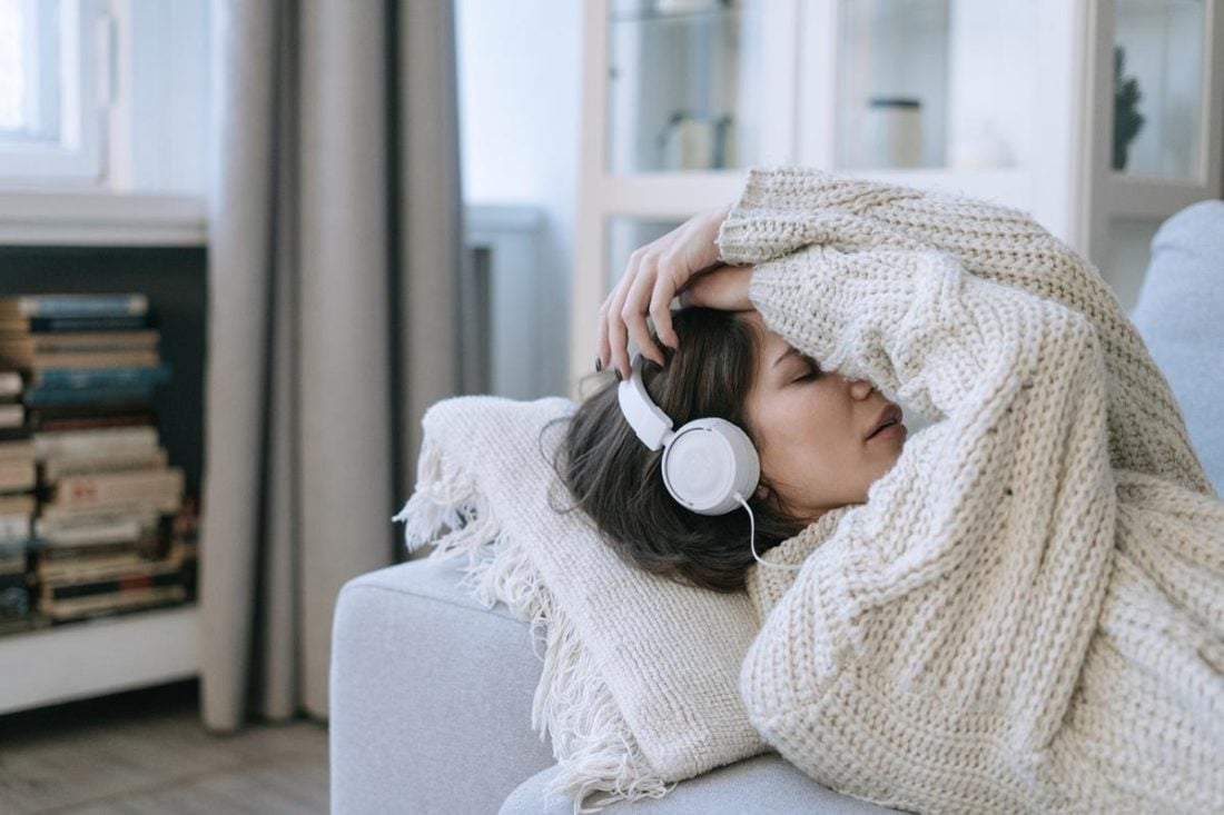 A Woman Wearing Headphones Seemingly in Discomfort