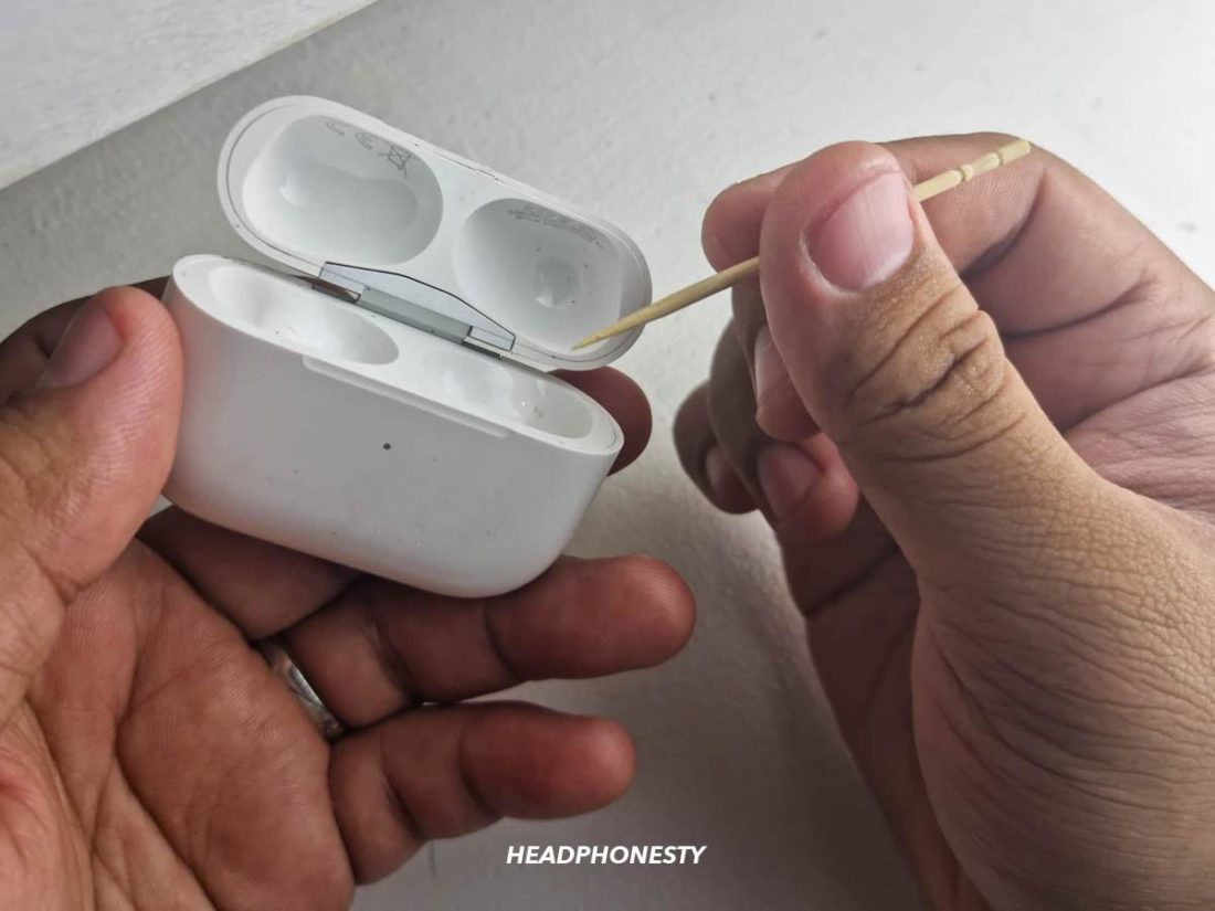 Using a toothpick to clean the AirPods case' crevices