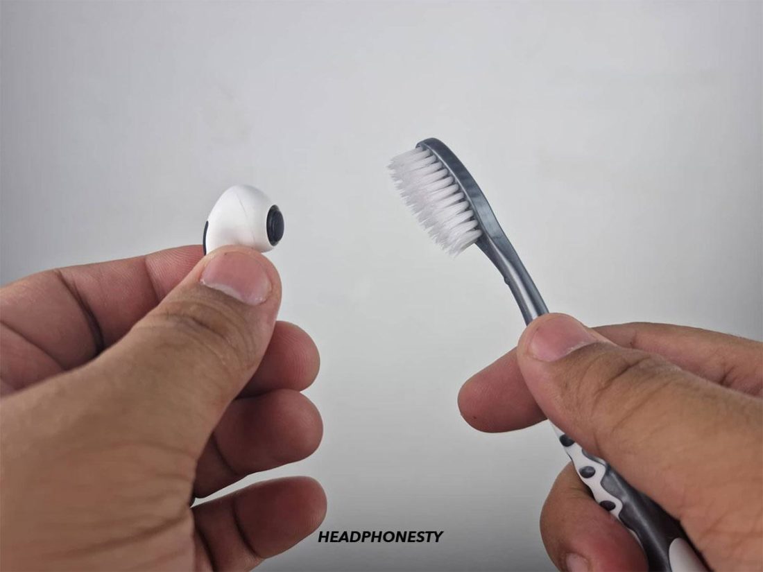 Using brush to clean the AirPods