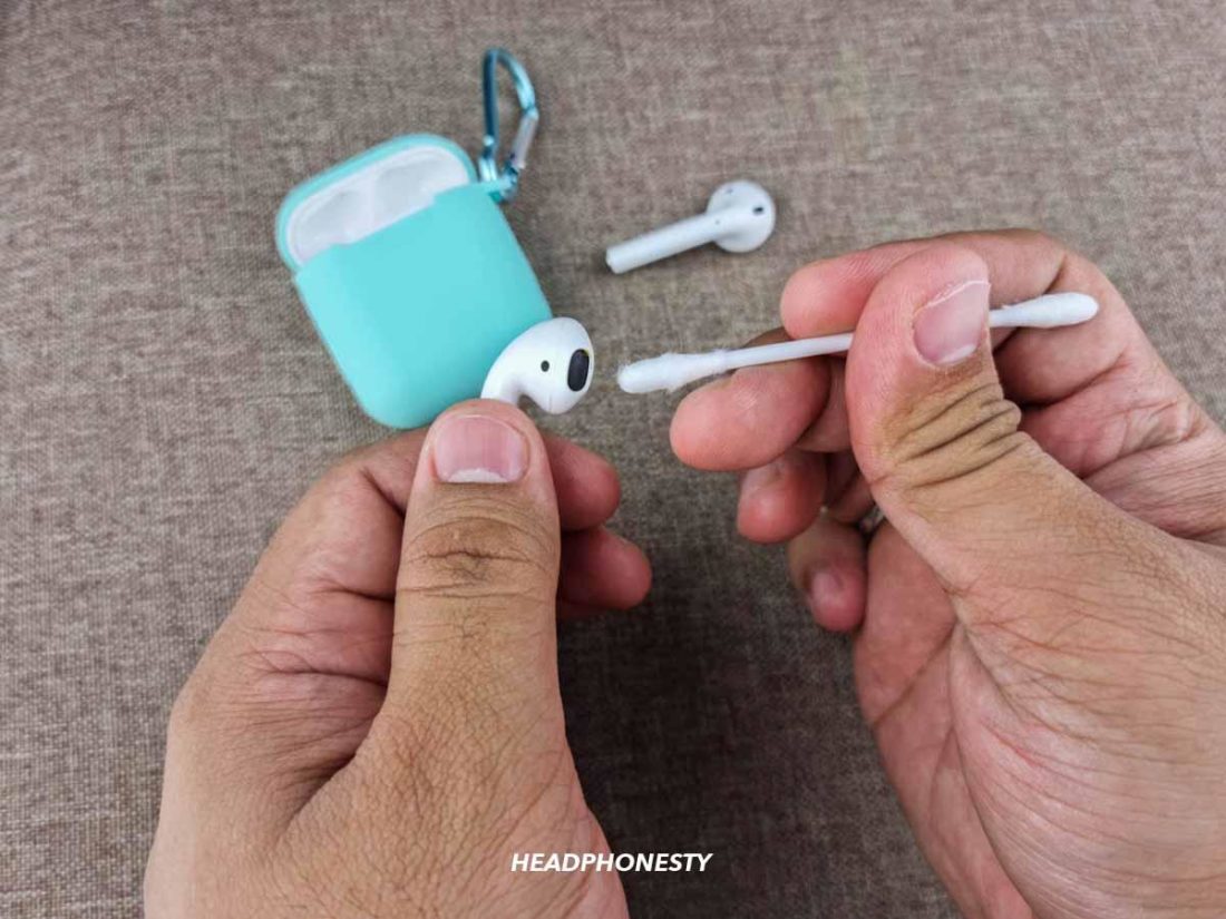 Cleaning AirPods with cotton swab.