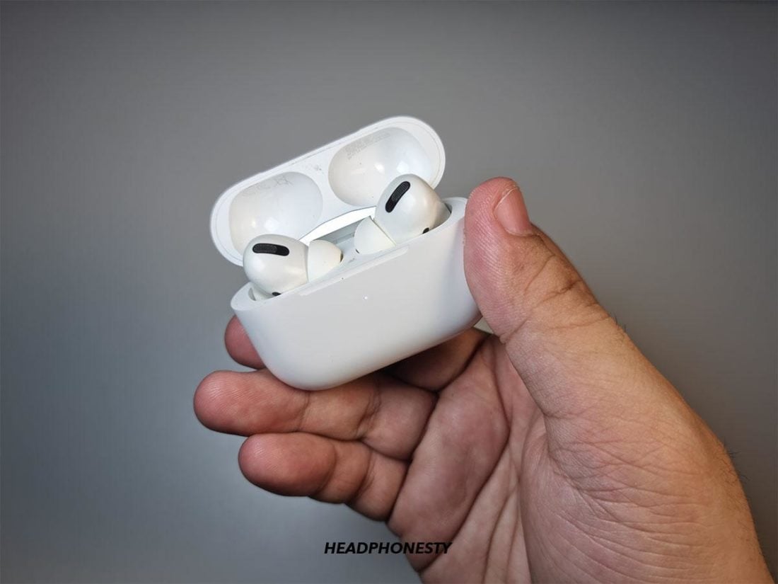 Holding AirPods Pro in the open charging case
