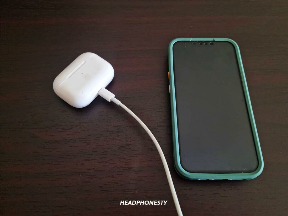 AirPods and case next to iPhone