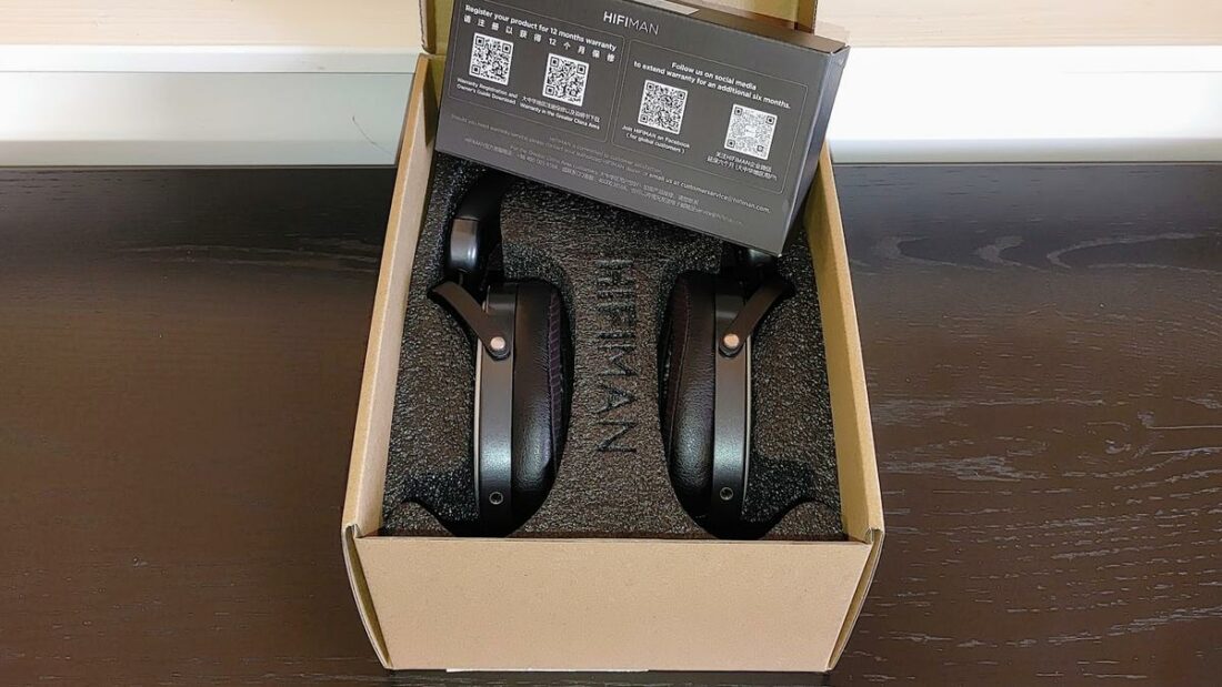 The box contains a foam insert, the headphones stand, and a small black box that holds the singular included cable.