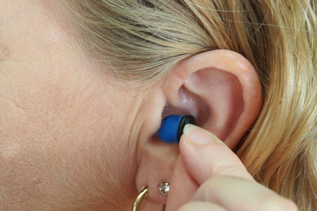 A woman wears an earplug on her ear. (From: Unsplash)