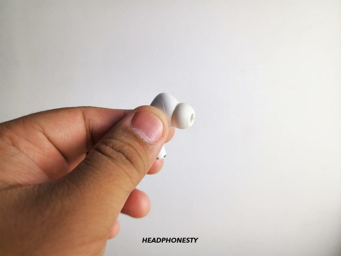 Holding AirPods Pro by the seam on the head