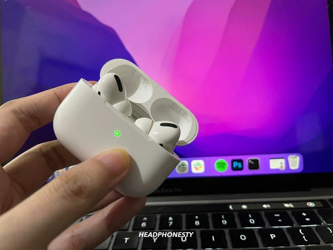 AirPods charging case showing green status light.