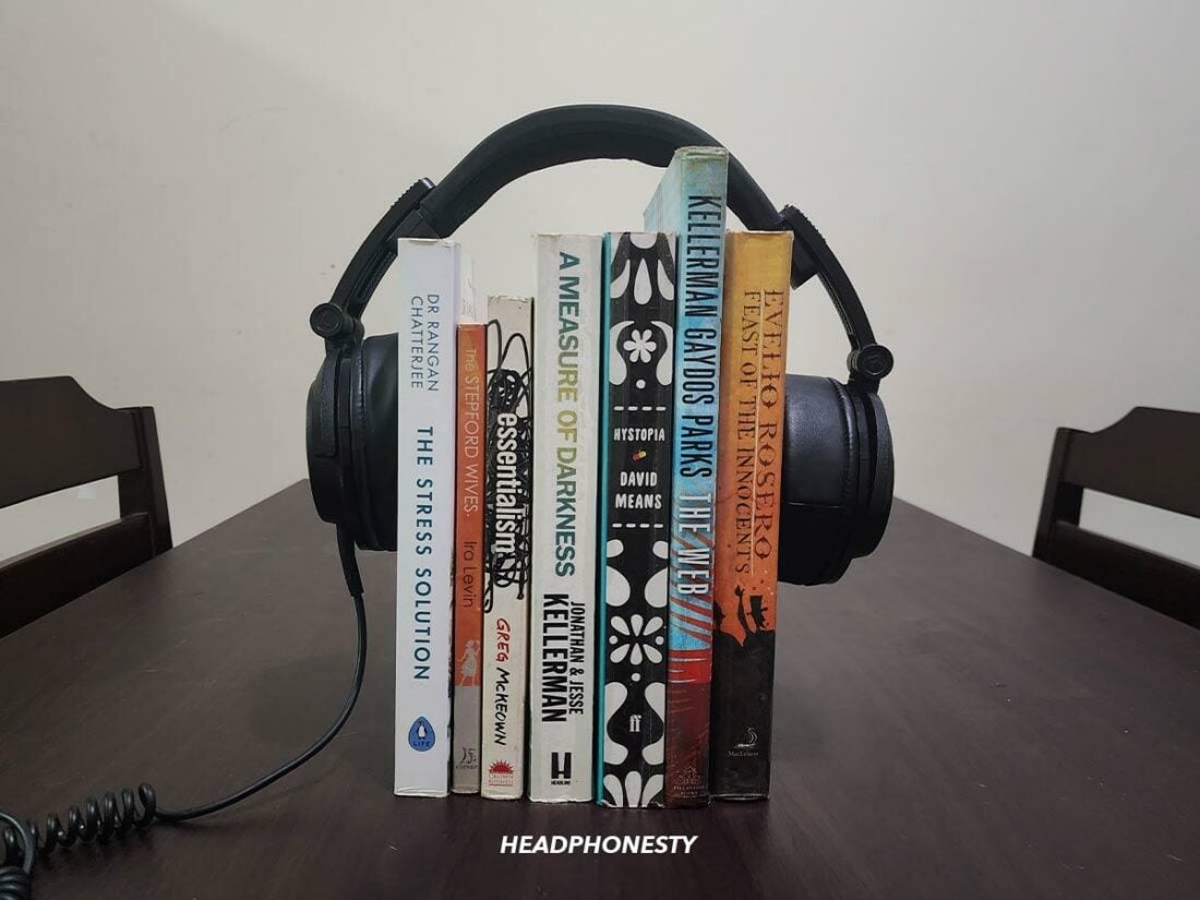 Headphones being stretched over a stack of books