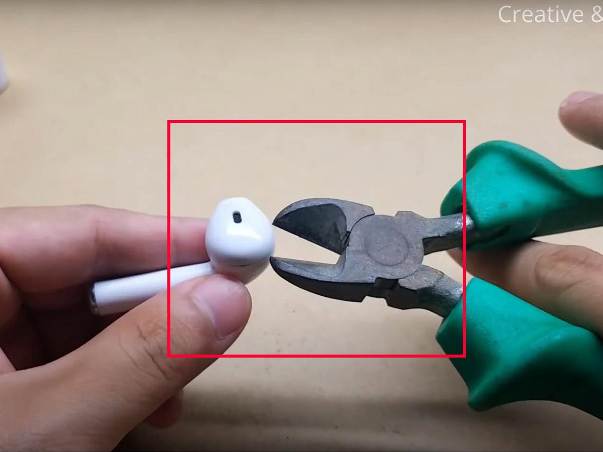 Using a pair of cutting pliers to open the casing of the earbuds. (From: Youtube/Creative & Duck)