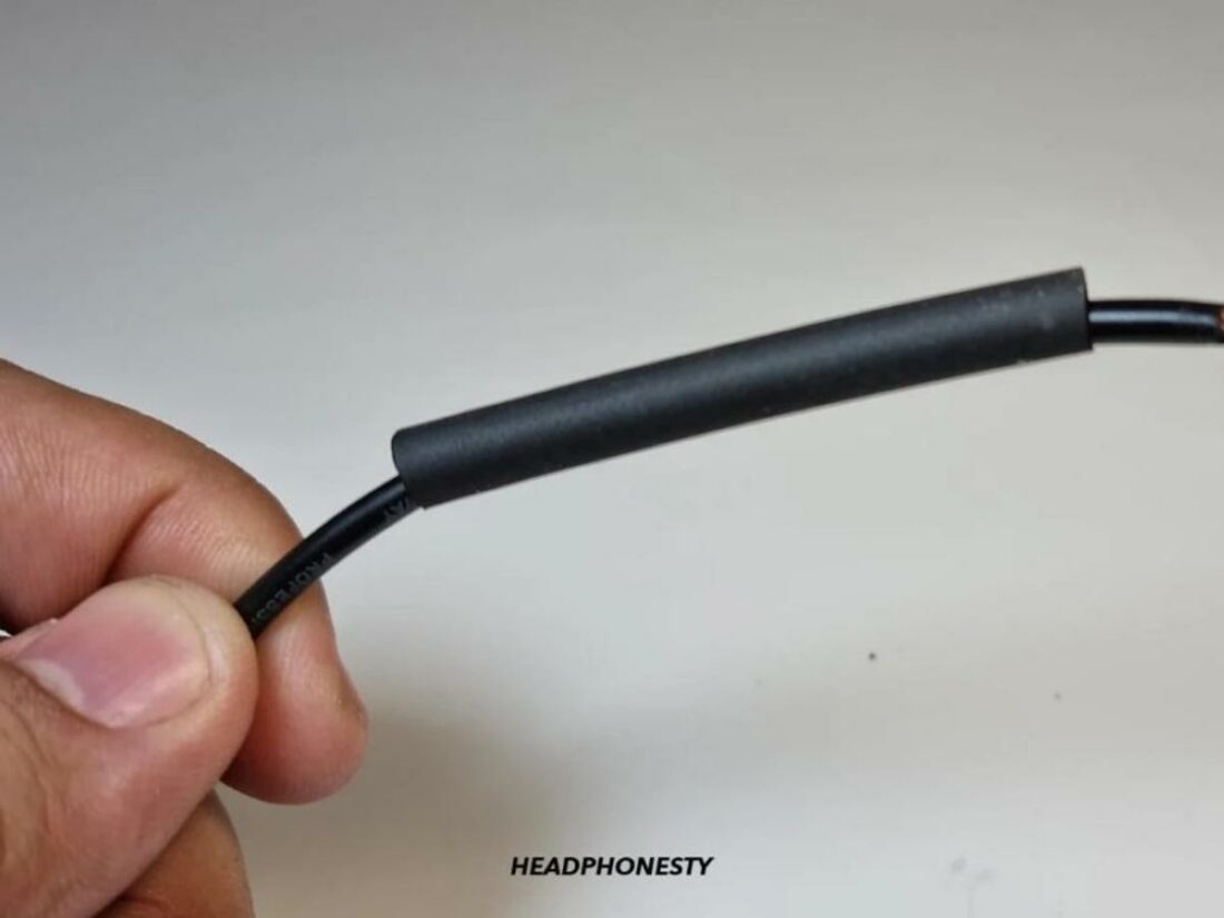 Insulate the wire with eletrical tape or heat-shrink tubing.