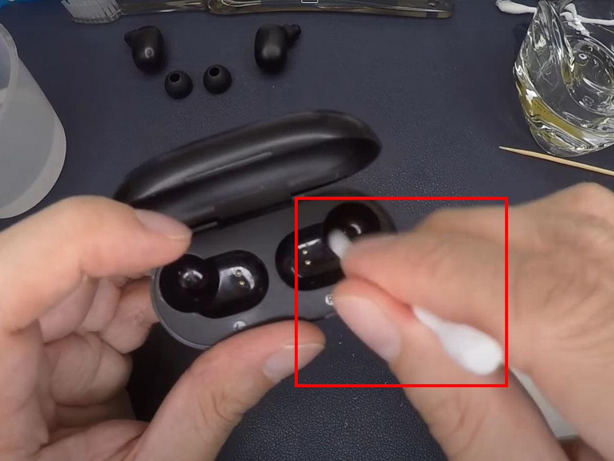 Use a cotton swab to wipe down the pins on your earbuds and charging case. (From: Youtube/ying Newton)