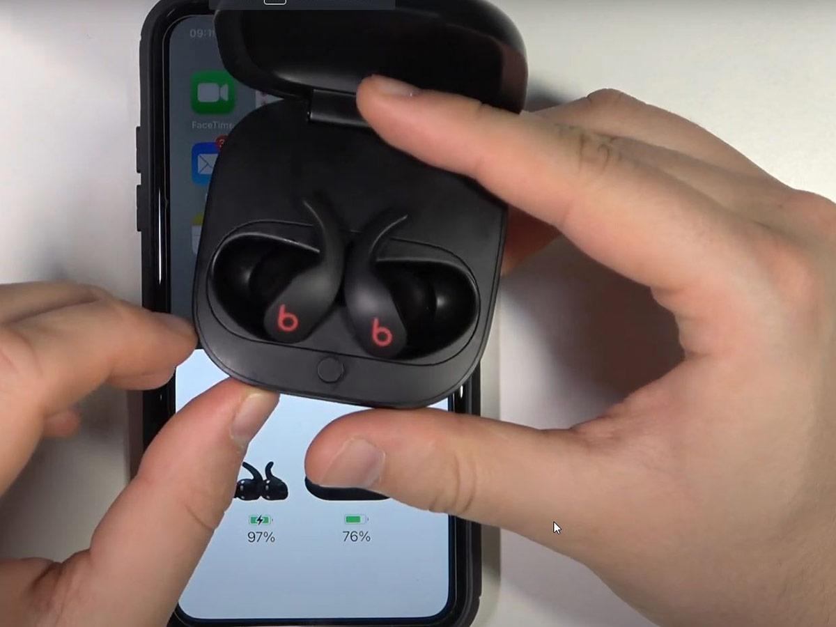 Put both earbuds in their charging case and leave the lid open. (From: YouTube/HardReset.Info)