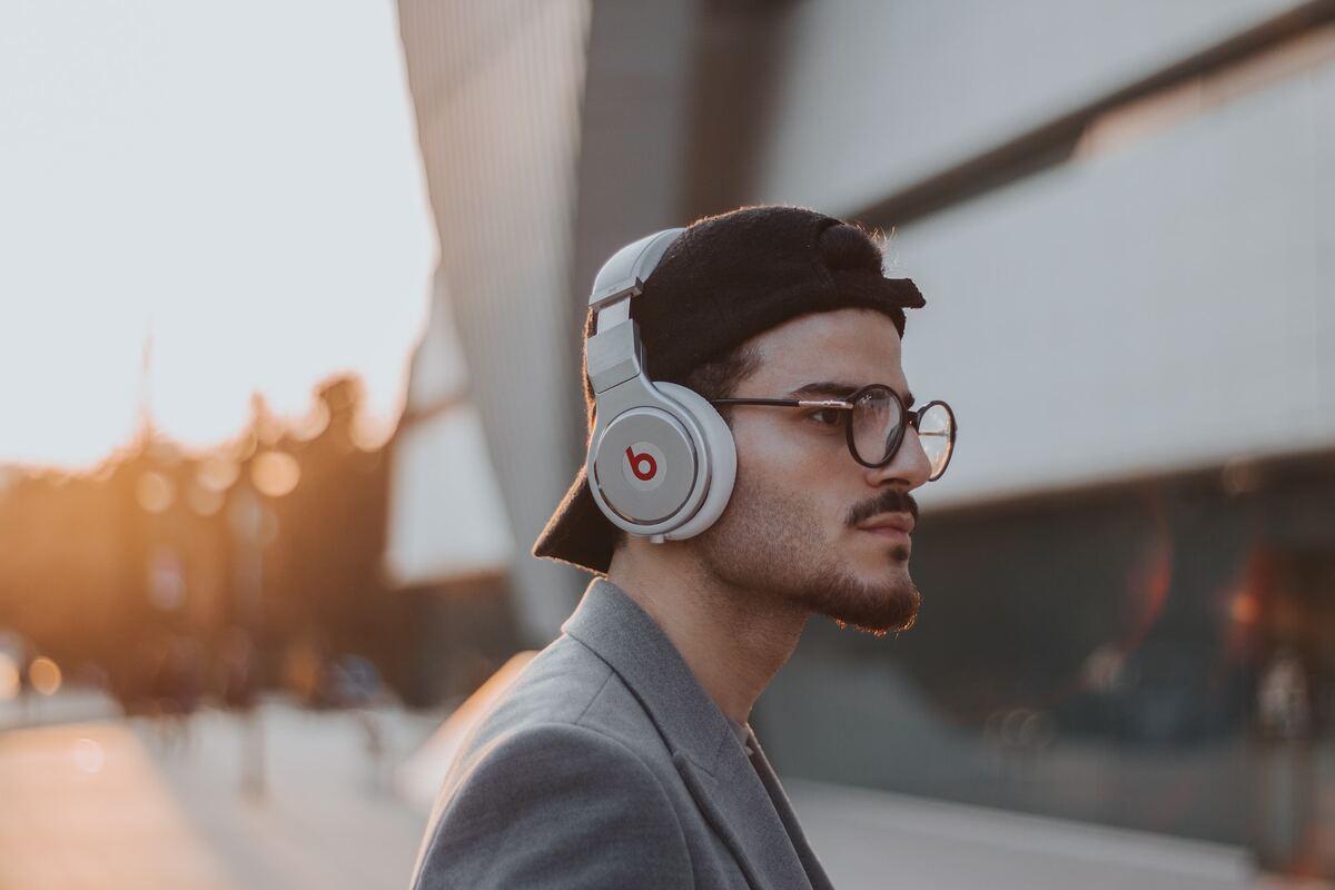 Man disappointed in his beats headphones' volume. (From: Unsplash)