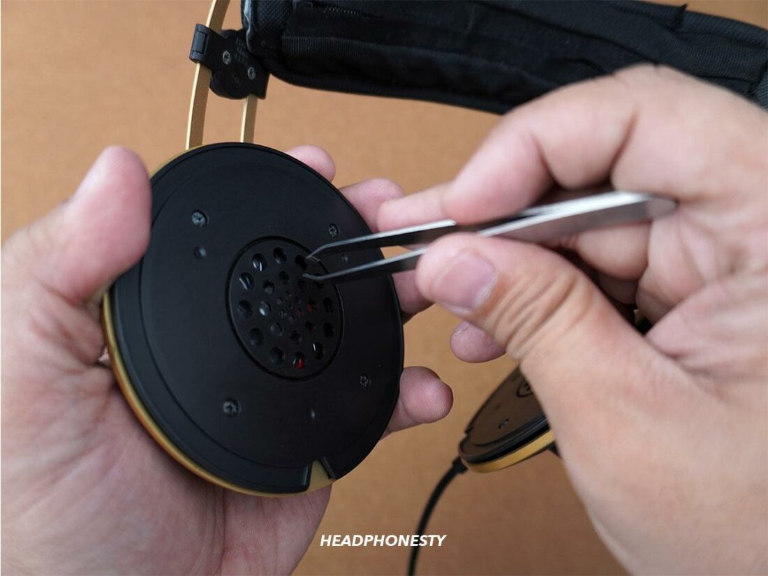 Use a pair of tweezers to help remove hair and other debris that may have gotten stuck in the headphone driver`s.