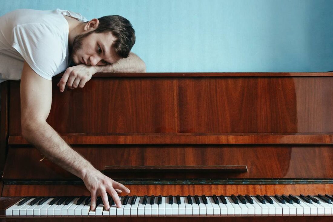 Man playing the piano in a melancholic state.
